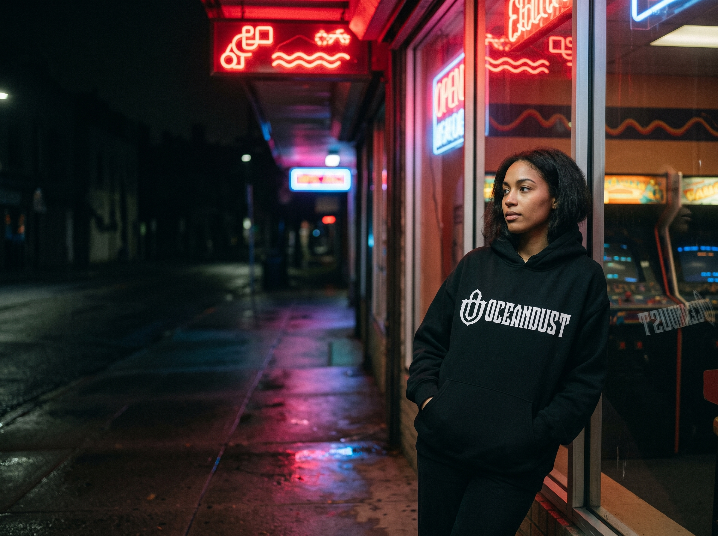 Woman in an oversized Oceandust hoodie outside a neon arcade